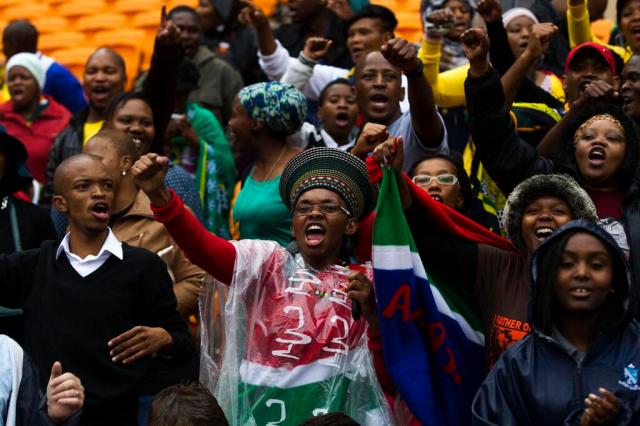 People sing and dance as they arrive at Nelson Mandela's memorial