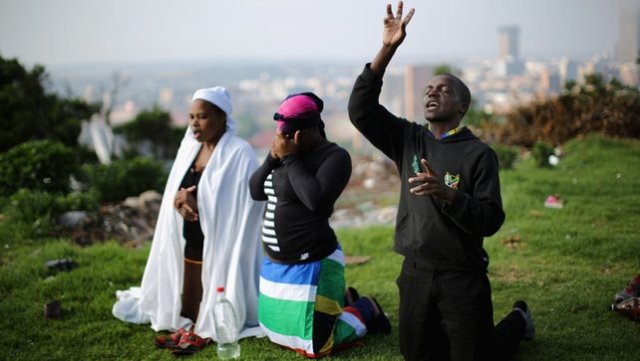People worship on a hill overlooking Johannesburg as they remember and mourn Nelson Mandela1