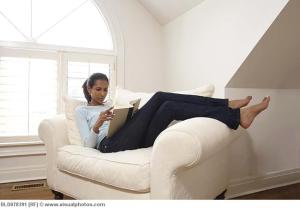 Black woman reading book in armchair