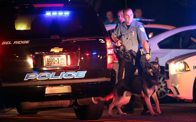 Police officers patrol the area Sunday, Aug. 10, 2014, in Ferguson, Mo.